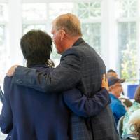 Former President Tom Haas chatting with President Mantella with an arm over her shoulder